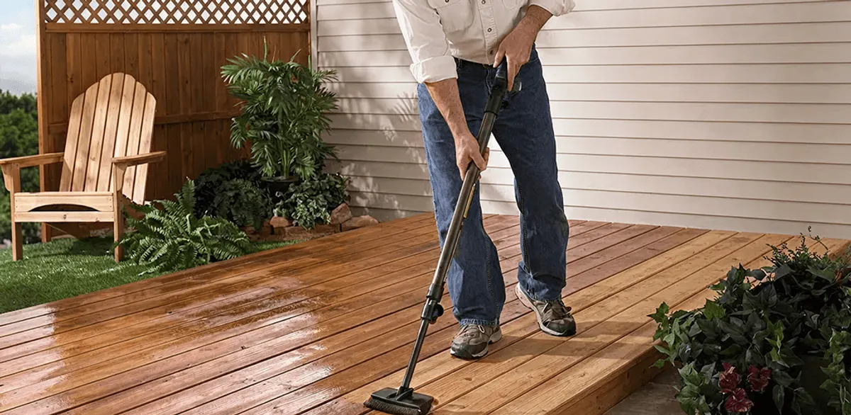 Deck staining service applying stain to a backyard wood deck in New Orleans, LA